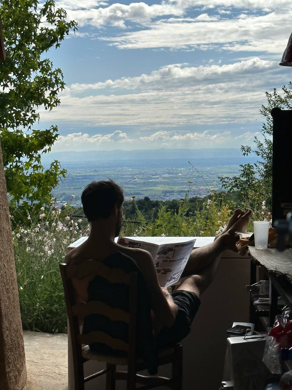 Andrea reading the news with a view over the valley